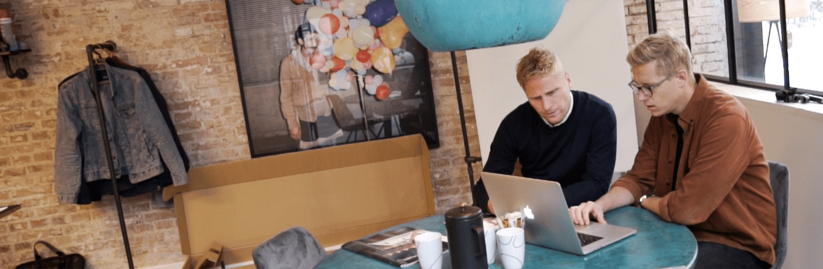 To kollegaer sidder og kigger på en computer sammen