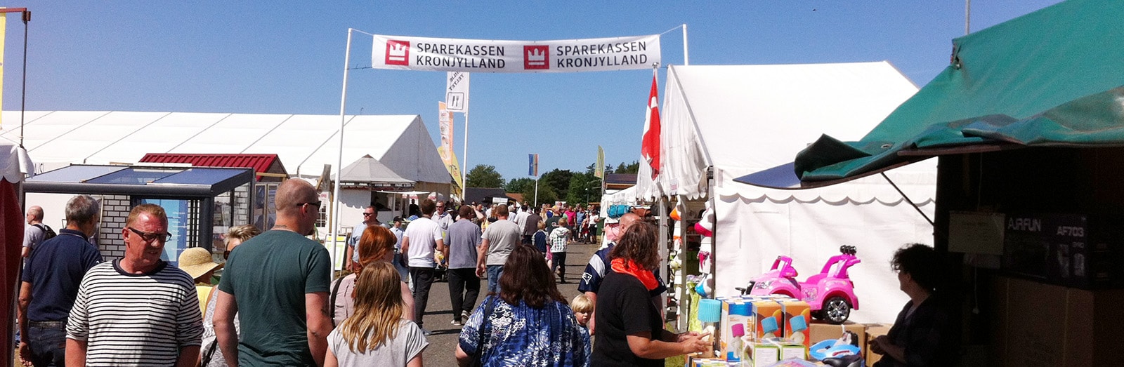 Banner med Sparekassen Kronjyllands logo og besøgende på Vorbasse Marked
